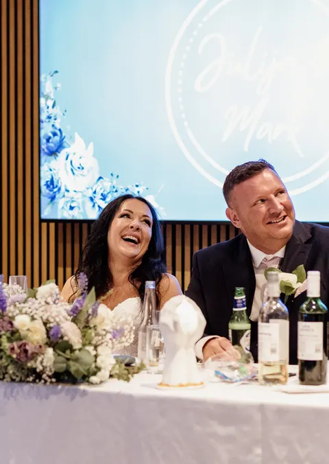 Bride and groom smiling during the wedding toasts
