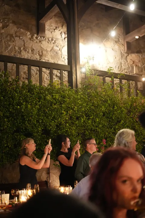 Guests filming the candlelit welcome dinner on their phones