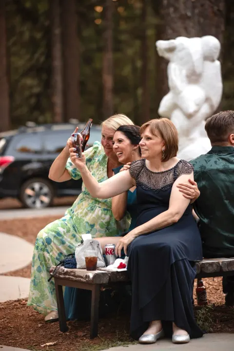 Group of guests laughing and taking a photo at a wedding